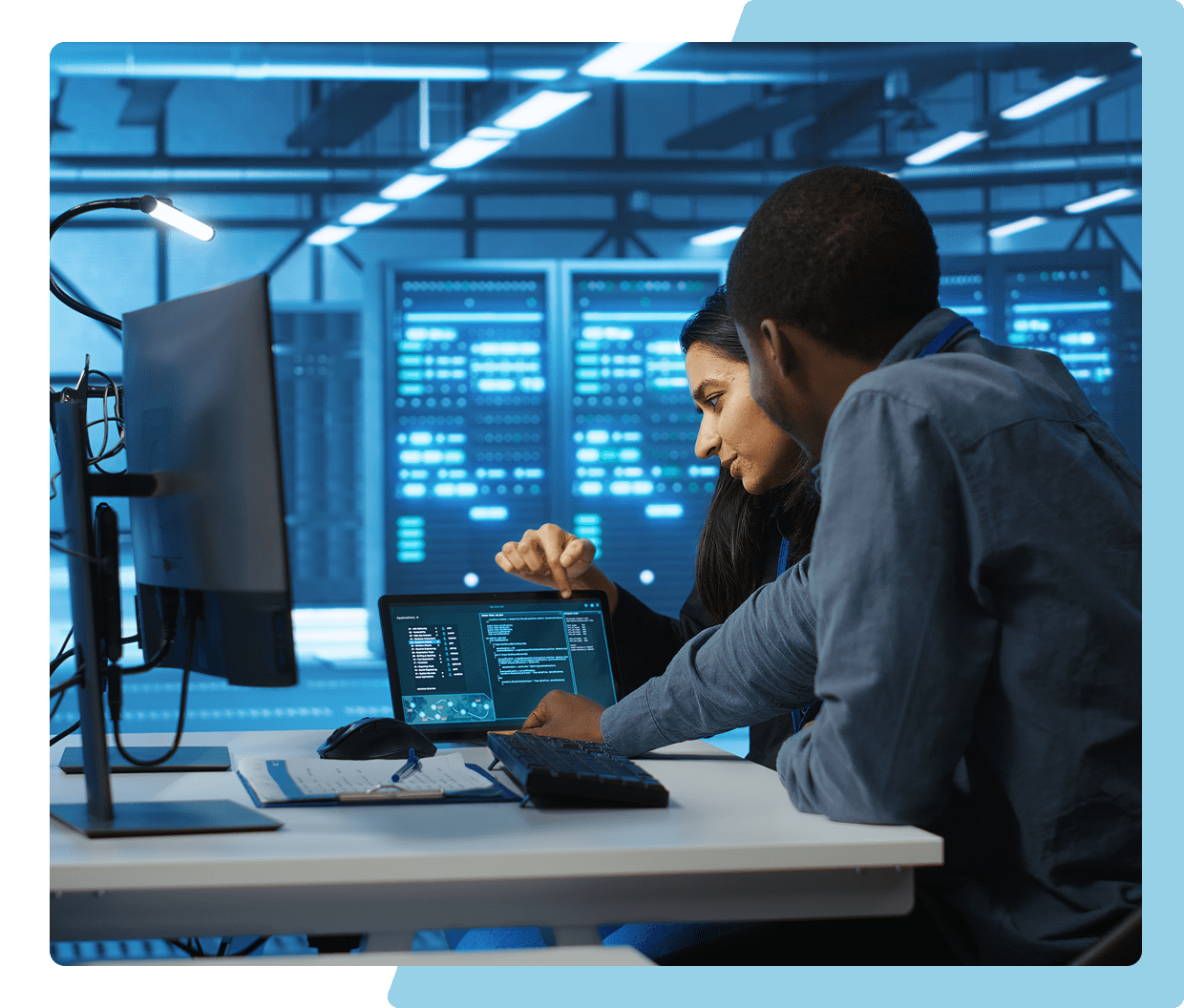 Two people discussing data on tablet screen.